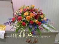 # MPCASK007 — $265.00 — Yellow Roses, Red Lilies, Red Carnations, Yellow Stocks, Blue Delphiniums, Pink Mini Roses, White Gladiolous, Two Tones Mini Carnations, Pink Spray Roses, Solidagos.. ~ Approximate size: 18″H x 38″W